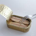 Sgombro in scatola su uno scaffale di supermercato, simbolo di crescente domanda alimentare.