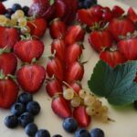 Torta decorata con frutta fresca colorata su un piatto elegante.