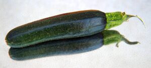 Zucchine grigliate condite con olio, aglio e spezie su un piatto elegante.