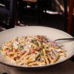 Borgo italiano con piatti tipici serviti in un ristorante caratteristico.